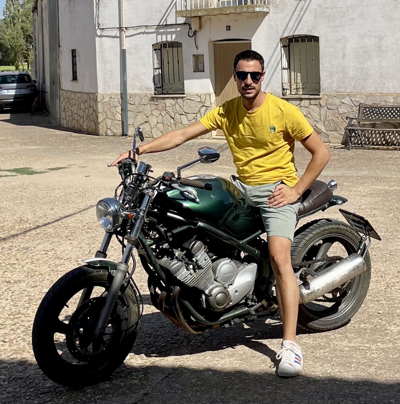 Daniel sobre una moto clásica de estilo café racer verde