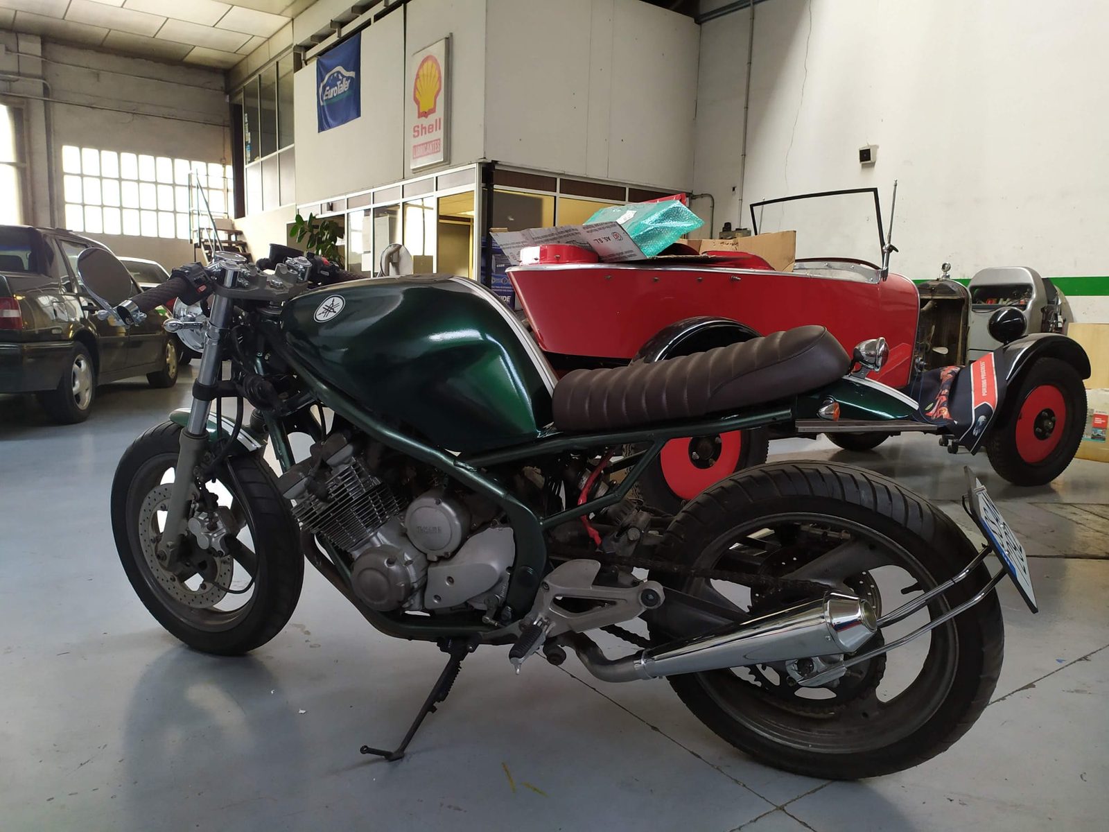 Moto café racer verde en un taller